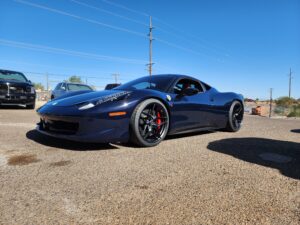 A blue sports car parked in the middle of a parking lot.