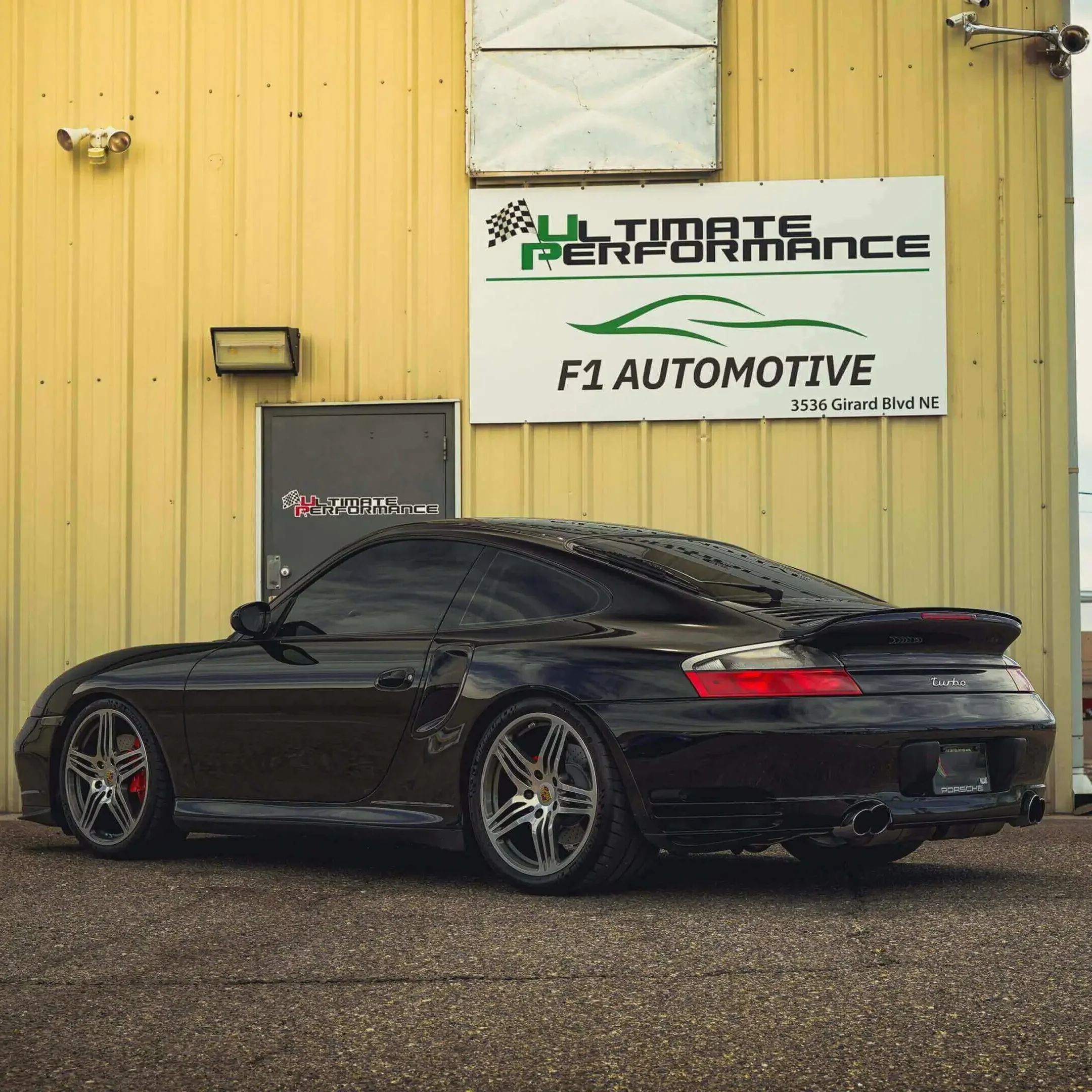 A black car parked in front of a building.